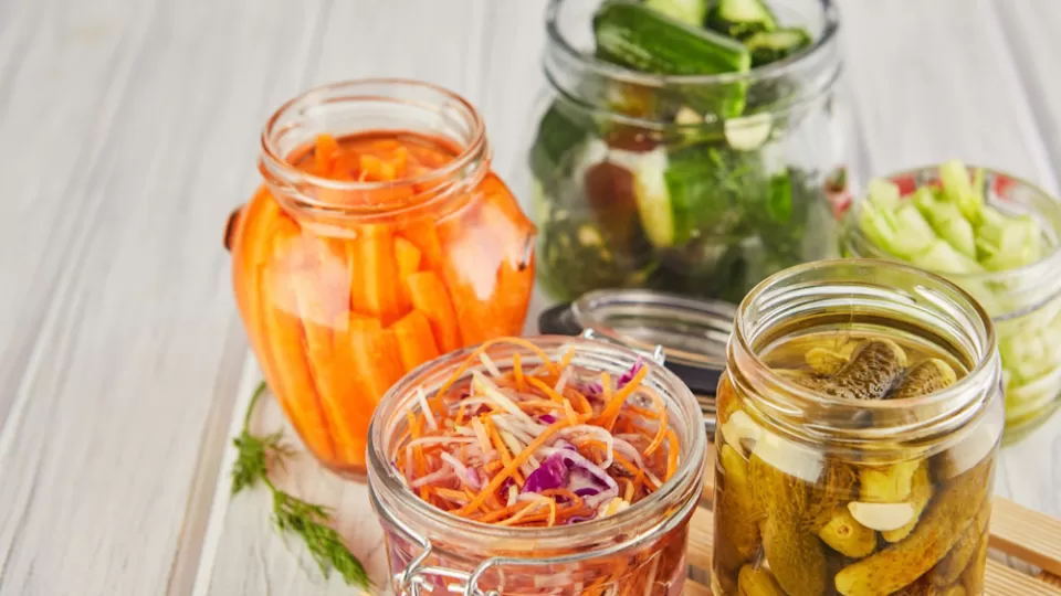 Five jars of different pickled vegetables.