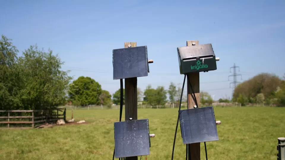 Irrigatia's automatic watering system set up against a wooden fence.