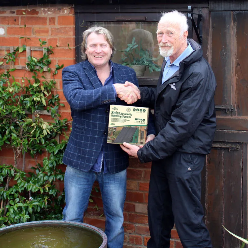 TV Gardener David Domoney and George Evans of Irrigatia shaking hands over an Irrigatia Solar Automatic Watering System