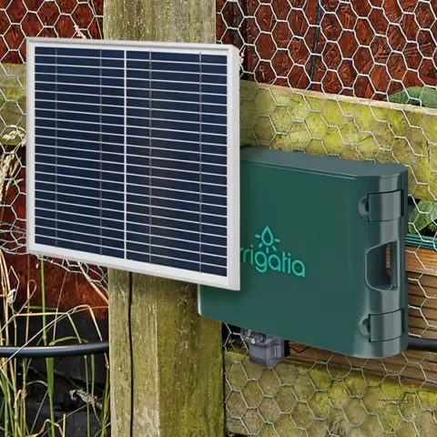 Woman using the SOL C180 irrigation kit to water a tomato plant