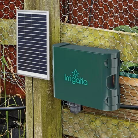 Woman using the SOL C60 irrigation kit to water a tomato plant